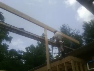 Carpenter setting a ridge beam over a new addition frame — Ice Dam Removal by Roofing Brothers in Hersey