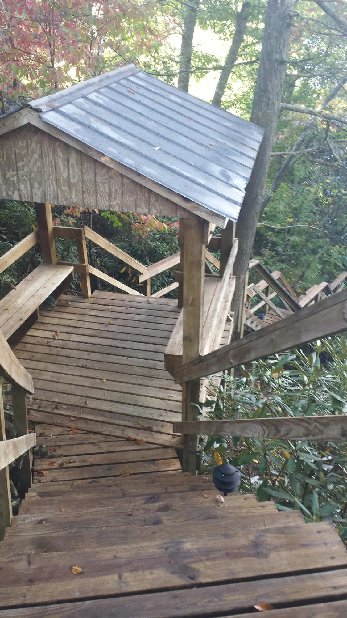 Metal roofed shelter over wooden steps on a wooded walkway — Skylight Repair & Installation work by our crew in Hersey