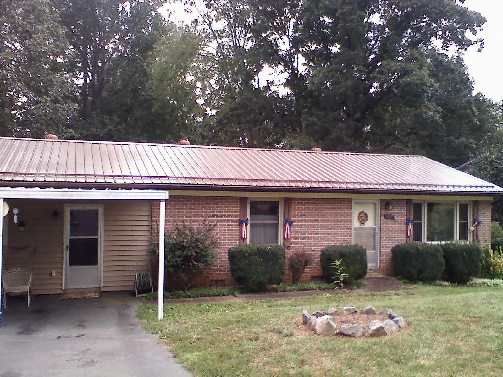 Bronze metal roof and carport on a brick ranch home — Roof Repair work by our crew in Hersey